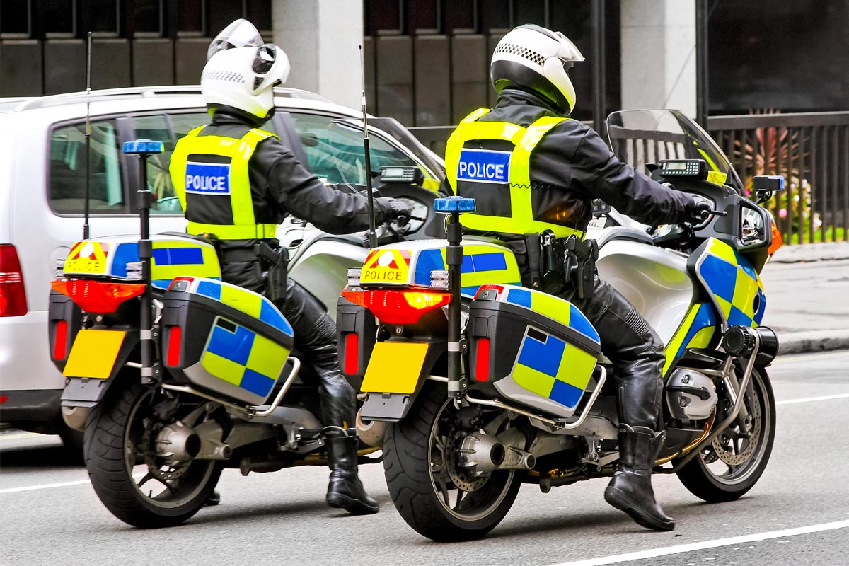 Police officers riding motorcycles wearing flip up helmets